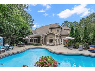Stunning backyard with a large pool, patio furniture, and lush landscaping perfect for outdoor entertaining at 3530 Thorndike Dr, Wake Forest, NC 27587