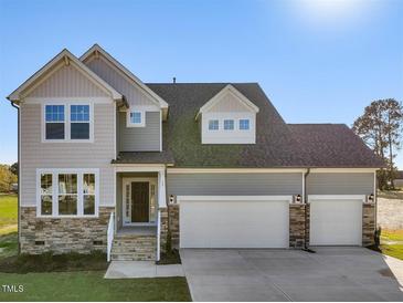 Inviting two-story home featuring a two-car garage and stone-accented facade at 426 Adams Pointe Ct, Angier, NC 27501