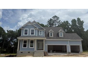 Charming two-story home featuring light blue siding, white trim, and an attached two-car garage at 426 Adams Pointe Ct, Angier, NC 27501