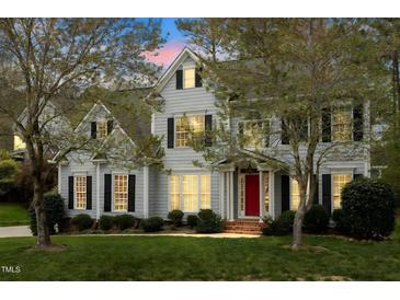 Charming two-story home boasts a manicured lawn, a bright red front door, and classic black shutters at 4313 Branchwood Dr, Durham, NC 27705