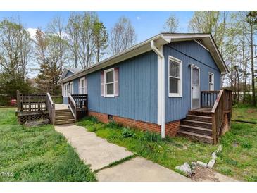 Charming one-story home with blue siding, brick foundation, and wooden porches at 4502 Mill Creek Rd, Cedar Grove, NC 27231
