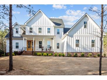 Beautiful white farmhouse with board and batten siding and a welcoming front porch at 494 Terry Rd, Hillsborough, NC 27278