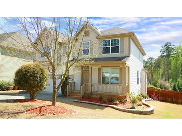 Charming two-story home featuring a welcoming front porch and beautifully landscaped yard at 504 Prince Dr, Holly Springs, NC 27540