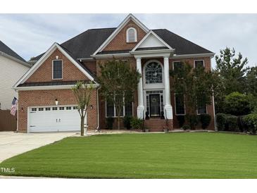 Beautiful red brick home with manicured lawn, attached two car garage and stylish front entrance at 6020 Jones Farm Rd, Wake Forest, NC 27587