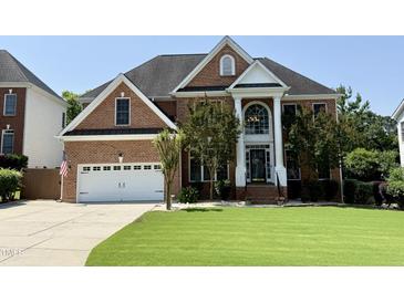 Beautiful brick home with a well-manicured lawn, attached garage, and grand entrance with columns at 6020 Jones Farm Rd, Wake Forest, NC 27587