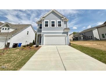 Charming two-story home with light blue siding and a spacious two-car garage on a sunny day at 91 Brooklynn Trl # 187, Angier, NC 27501