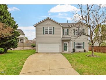 Charming two-story home with a well-maintained lawn, attached garage, and green shutters at 109 Wyeth Meadows Ln, Holly Springs, NC 27540