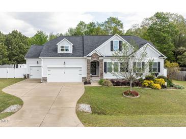 Charming home featuring stone accents, an attached two-car garage, and manicured landscaping at 175 Brazil Nut Ln, Smithfield, NC 27577