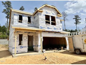 New two-story home showing exterior construction with attached two car garage and building wrap at 180 Muskogee Rd # 53, Angier, NC 27501