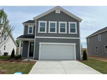 Charming two-story home with gray siding and a spacious two-car garage, nestled in a well-manicured lawn at 183 Little Crk Dr, Lillington, NC 27546