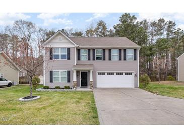 Charming two-story home featuring a well-maintained lawn and a two-car garage at 211 Richmond Run, Stem, NC 27581