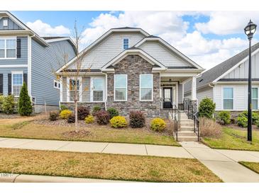 Charming home featuring stone accents, manicured landscaping, and a welcoming front porch at 233 Stone River Dr, Wendell, NC 27591