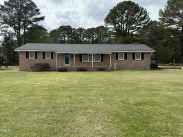 Charming brick ranch-style home with well-maintained lawn and mature trees providing shade at 2886 Steven'S Chapel Rd, Smithfield, NC 27577