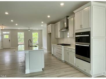 Open-concept kitchen with stainless steel appliances, a large island, and bright natural light at 486 Traditions Grande Blvd # 28, Wake Forest, NC 27587