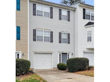 Charming two-story townhouse with a one-car garage, black shutters, and manicured bushes at 5163 Sandy Banks Rd, Raleigh, NC 27616