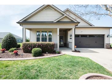 Charming home featuring manicured lawn, flowerbeds, and a two-car garage at 135 Brocks Trce, Burlington, NC 27215
