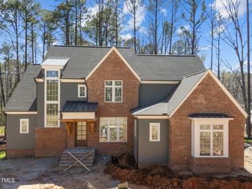 New two-story home with mixed brick and gray siding, dark roof, and a charming covered front porch at 1425 Lake Adventure Ct, Raleigh, NC 27613