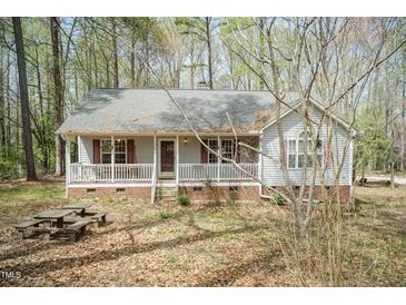 Charming single-story home with a welcoming front porch and mature trees at 1508 Middle Ridge Dr, Willow Springs, NC 27592