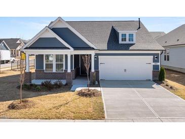 Charming craftsman-style home featuring a two-car garage and a mix of brick and siding accents at 1801 Angelonia Way, Fuquay Varina, NC 27526