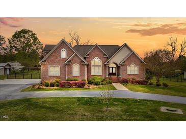 Charming brick home with a well-manicured lawn and inviting front entrance at sunset at 2011 Gibsonville Ossipee Rd, Elon, NC 27244