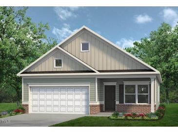 Charming one-story home featuring a two-car garage, green lawn, and manicured landscaping at 291 Deodora Ln, Cameron, NC 28326