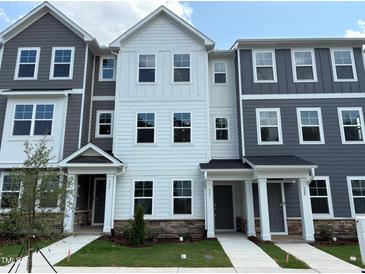 Attractive exterior elevation showcasing three-story townhomes with contemporary gray and white siding and stone accents at 331 Deercroft Dr, Apex, NC 27539