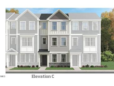 Charming townhome showcases a three-story exterior with varied siding and stone accents at 331 Deercroft Dr, Apex, NC 27539