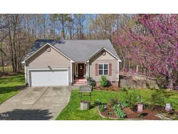 Charming single-story home with an attached garage, lovely front yard, and delightful landscaping at 85 Rolling Cloud Dr, Louisburg, NC 27549