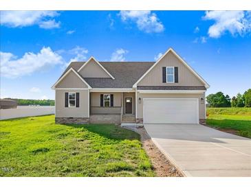 Charming home featuring neutral siding, a covered porch, and an attached two-car garage at 9744 Bear Run Ln, Middlesex, NC 27557