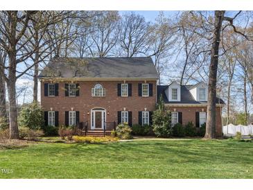 Beautiful two-story brick home with black shutters and a well-manicured lawn, surrounded by mature trees at 1005 Brookview Dr, Elon, NC 27244