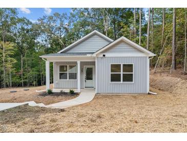 Charming single-story home with a modern gray exterior and inviting front entrance at 111 Halifax Rd, Louisburg, NC 27549