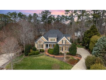 Charming traditional two-story home featuring a landscaped yard, brick walkway, and neutral color palette at 111 San Juan Dr, Chapel Hill, NC 27514