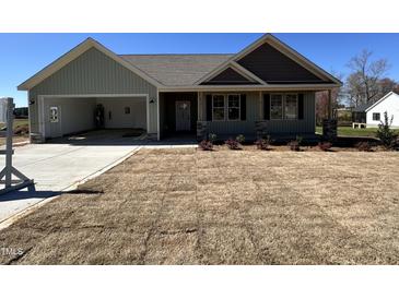 Charming one-story home featuring a spacious garage, covered porch, and beautifully landscaped front yard at 141 Ruskin Dr, Smithfield, NC 27577