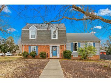 Charming two-story home with brick and vinyl siding, blue shutters and a neatly manicured lawn at 2319 Somers Ave, Burlington, NC 27215