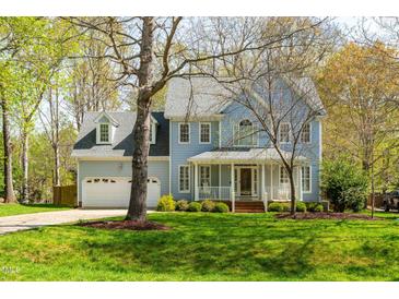 Charming two-story home with a manicured lawn, attached garage, and lovely front porch at 2868 Anfield Rd, Raleigh, NC 27606