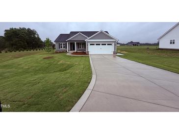 Charming single-Gathering home with a well-manicured lawn and a concrete driveway at 32 Tanseyleaf Dr, Smithfield, NC 27577
