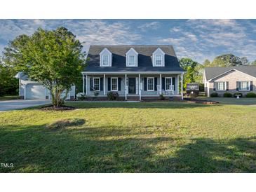 Charming two-story home featuring a welcoming front porch with swing and rocking chairs at 35 Fairway Ct, Dunn, NC 28334