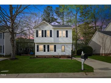 Charming two-story home with a well-manicured lawn, classic black shutters and a paved driveway at 3717 Phillips W Way, Durham, NC 27713
