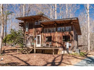 Charming rustic house with a wooden deck surrounded by trees, offering a serene and private setting at 4401 E L G Rd, Efland, NC 27243
