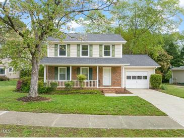 Charming two-story home with brick facade, green shutters, a front porch, and attached garage at 4508 Fox Rd, Raleigh, NC 27616