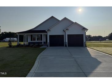 A charming, white two-car garage home with a well manicured lawn and concrete driveway at 47 Silver Ct, Smithfield, NC 27577