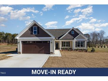 Charming home with brown garage door, light siding, and covered entrance at 48 Tanseyleaf Dr, Smithfield, NC 27577