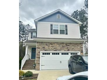 Two-story home with stone accents, attached garage, and well-maintained front yard at 50 Teal Dr, Youngsville, NC 27596