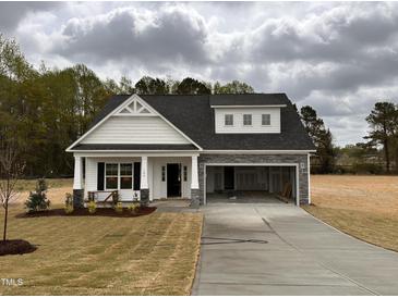 Charming single-story home with white siding, stone accents, and an attached two-car garage at 105 Tuskeegee Dr, Smithfield, NC 27577