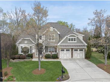 Charming two-story home with a well-manicured lawn, attached two-car garage, and a beautifully landscaped front yard at 113 Woodland Ridge Ct, Cary, NC 27519
