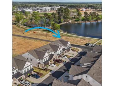Aerial view of new townhomes in a vibrant community near a lake and green spaces, offering a peaceful setting at 125 Paperwhite Pl, Clayton, NC 27527