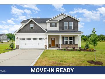 Beautiful two-story home featuring a two-car garage, covered porch, and manicured lawn at 141 Trescott St, Smithfield, NC 27577