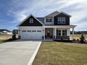 Charming two-story home with a well-manicured lawn and attached two-car garage, complete with traditional architectural details at 141 Trescott St, Smithfield, NC 27577