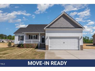 Charming one-story home featuring a two-car garage, covered porch and manicured front lawn at 143 Royal Ave, Selma, NC 27576