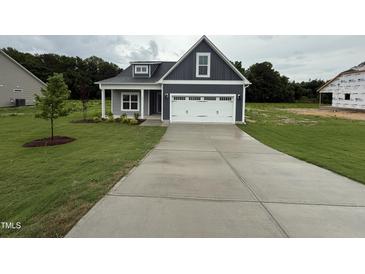 Charming home with a well-manicured lawn and a spacious two-car garage at 147 Tuskeegee Dr, Smithfield, NC 27577